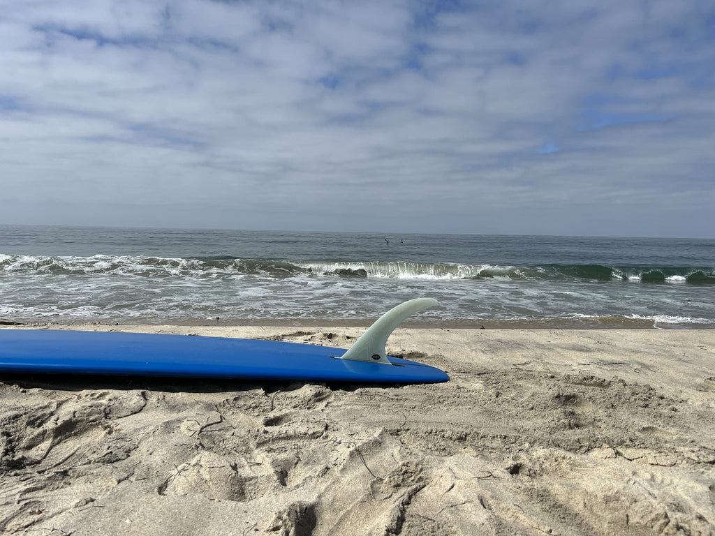 Bing Speed fin in a blue surfboard on the beach.