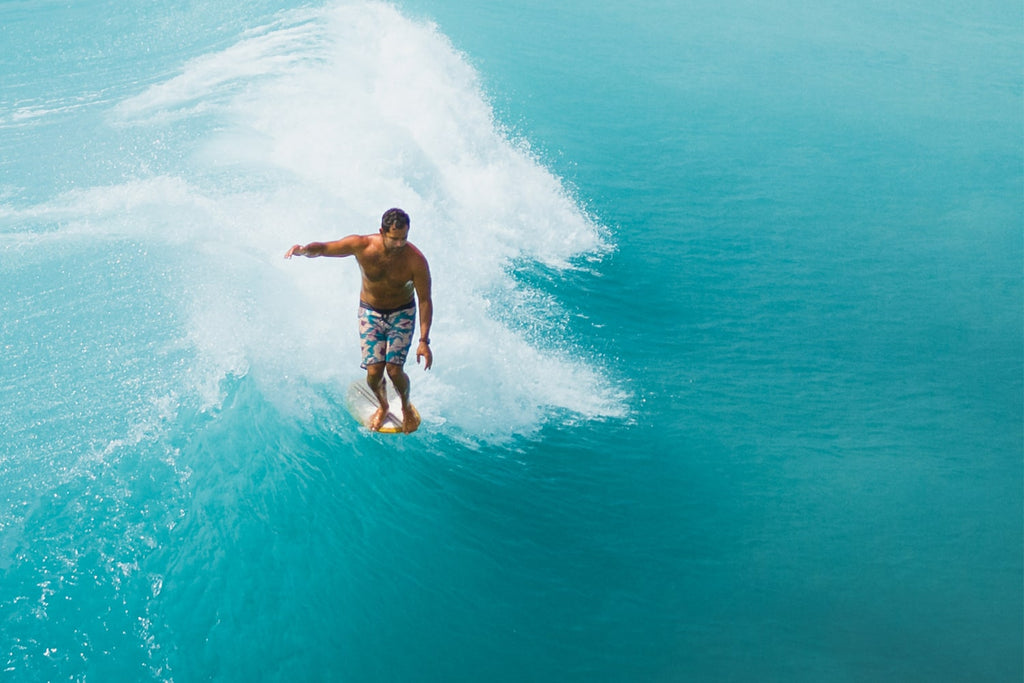 Aerial shot of Kai Sallas on the nose in tropical blue waters.